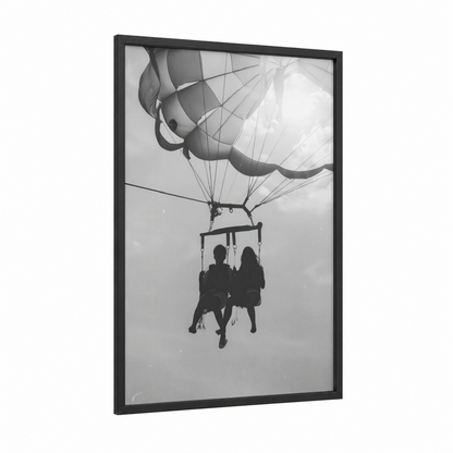 Skybound Couple framed parasailing print — black wood frame — black and white palette