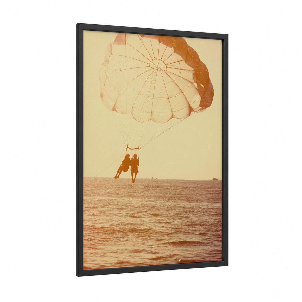 Golden Parasailing Duo framed art print — black wood frame — peach and cream palette